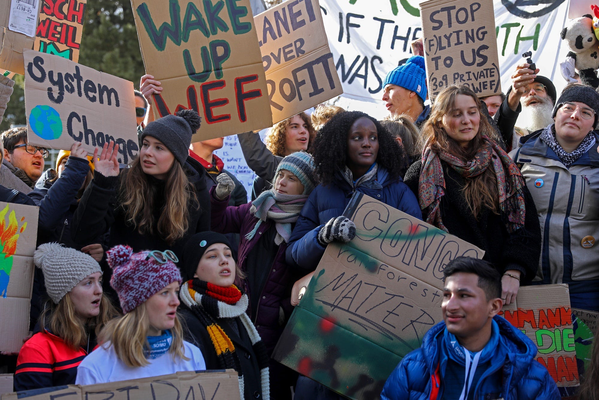 Climate activists Greta Thunberg, center, Vanessa Nakate, center right, Isabelle Axelsson, bottom third left, and Luisa Neubauer, center left, hold placards while taking part in a demonstration on the closing day of the World Economic Forum in Davos, Switzerland, on Jan. 24, 2020.